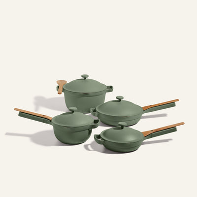 The non toxic cookware set - pots and pans set features four green pots and pans with wooden handles and matching lids, displayed on a neutral background.