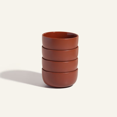 Four stacked reddish-brown Soup Bowls sit on a light background, casting a soft shadow to the left—an elegant example of modern tableware.
