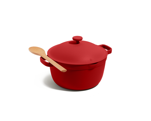 The Perfect Pot, a red family-sized Dutch oven with a matching lid and a wooden spoon on top, set against a plain white background.