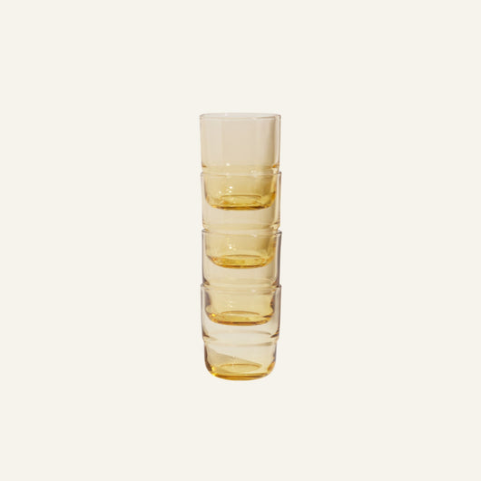Five Short Night + Day Glasses in translucent amber are stacked vertically against a plain light background.
