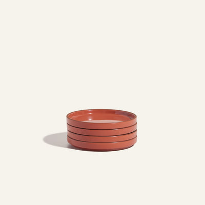 Set of three round, shallow Dessert Plates in a warm reddish-brown finish, arranged on a plain light background with a soft shadow to the left.