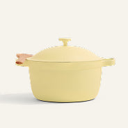 The Ceramic Nonstick Perfect Pot 6.5 qt. features a yellow ceramic exterior, a matching lid, and side handles—one equipped with a light brown grip. This versatile 8-in-1 nonstick pot is ideal for preparing family-sized meals and seamlessly transitions from stovetop to oven. The background is plain and light-colored.