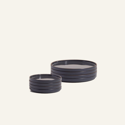Two stacks of the Small Plates Set in dark ceramic, one smaller and one larger, are arranged on a plain light background.