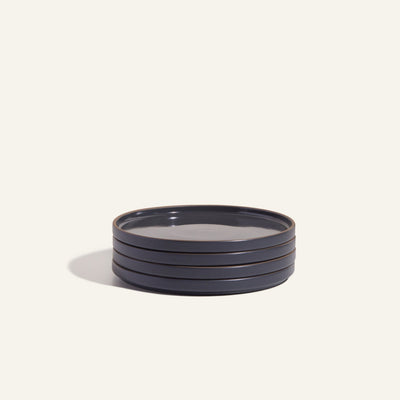A set of four round, dark blue Salad Plates is displayed on a light background, showcasing elegantly crafted hand-glazed tableware.