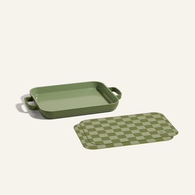 Mini Griddle Pan with handles displayed beside matching Mini Oven Mats in green checker pattern, shown on a light background.