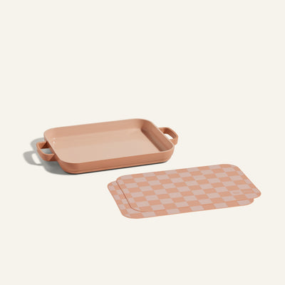 A Mini Griddle Pan with handles is displayed beside matching Mini Oven Mats on a plain background.
