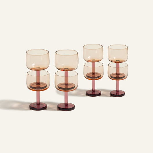 Set of six Party Coupes featuring colorful, amber-tinted bowls and dark red bases. Arranged in two rows on a light background, this vibrant glassware set is perfect for parties and stylish entertaining.