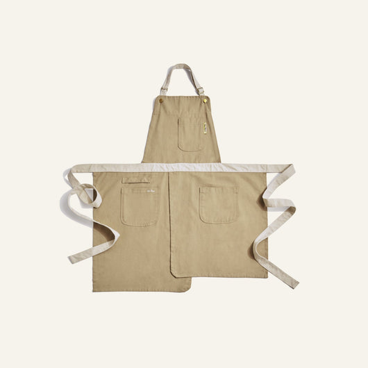 Beige apron with white straps on a light beige background