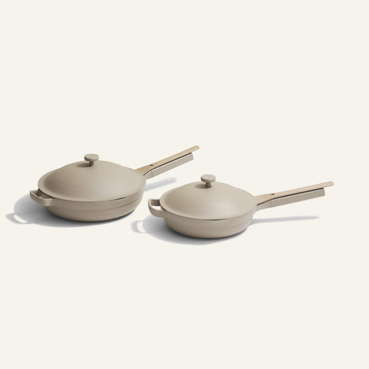 The non toxic ceramic nonstick always pan Duo features two beige ceramic sauté pans with matching lids and handles in different sizes, placed side by side on a light background—highlighting their versatile cookware style.