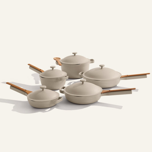 Set of beige cookware with wooden handles on a white background