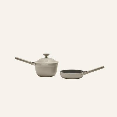 The Tiny Cookware Duo, featuring a gray saucepan with lid and a matching frying pan, both with long handles, is displayed on a plain light background.